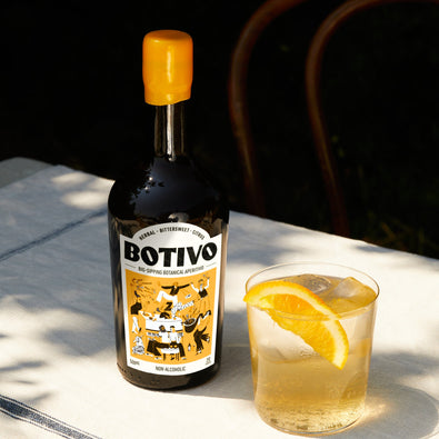 Botivo and soda: Botivo bottle beside a glass of Botivo on ice with an orange slice