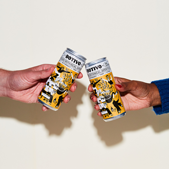 Two hands clinking cans of Botivo and soda