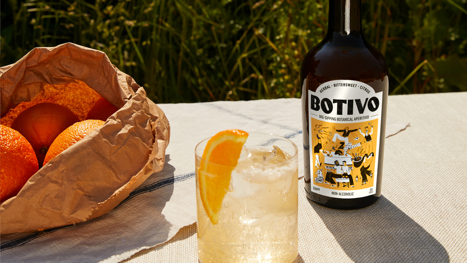 Botivo Batch 46 bottle and glass of Botivo with orange on a sunny table