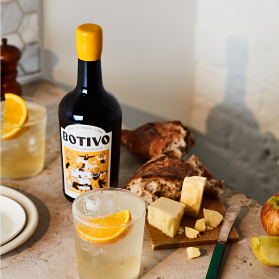 Botivo Batch 46 bottle with glasses of Botivo and orange beside bread and cheese