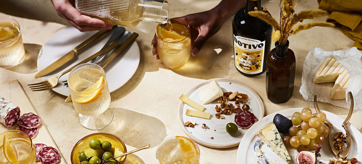 Overhead shot of a table shared with cheese, charcuterie, olives, glasses of Botivo and a Botivo bottle